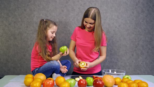 Mother with daughter making salad. Daughter and mother together preparing healthy organic food