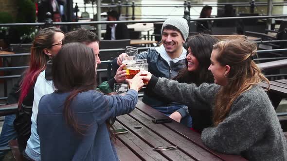 Group of friends enjoying a beer at pub in London