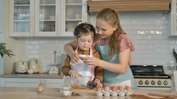 Mom and Daughter Cook Delicious Holiday Cookies Together in the Kitchen, Break a Chicken Egg