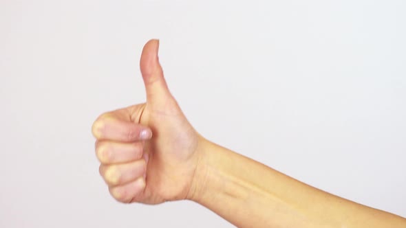 A Woman Shows a Thumb Up To the Camera - Closeup on the Hand - White Screen Background