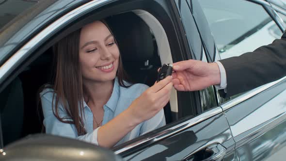 Sales Manager Handing Over the Keys To Girl That Sitting in the Car.