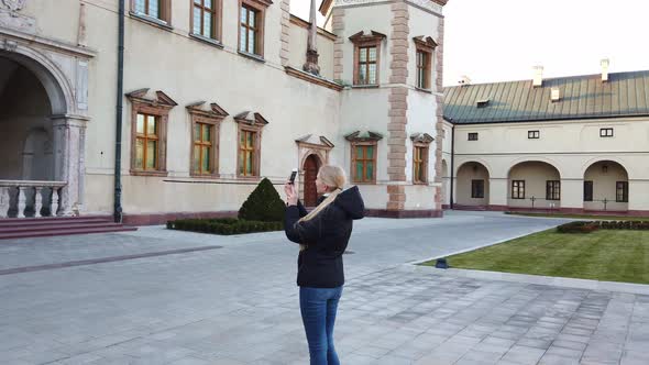 Girl Tourist Makes a Photo of Palace in the Old Square