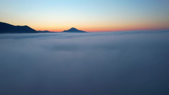 4K Aerial video Beautiful sunrise above dense clouds and fog in the morning, Cinematic drone shot.