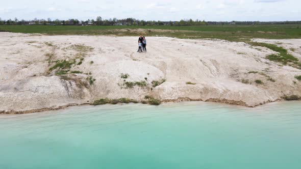 Drone Flying Low Over Travel Family at Lake Shore Journey of Mother Father Daughter