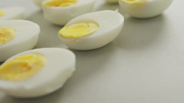 Video of close up of halves of hard boiled eggs on grey background