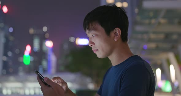 Man use of mobile phone in Hong Kong city at night