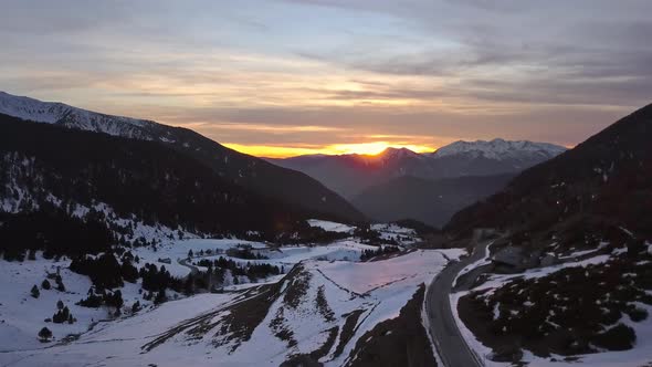 Smooth zoom drone out of the Cortals valley at golden hour, in the background the Pyrenees mountains