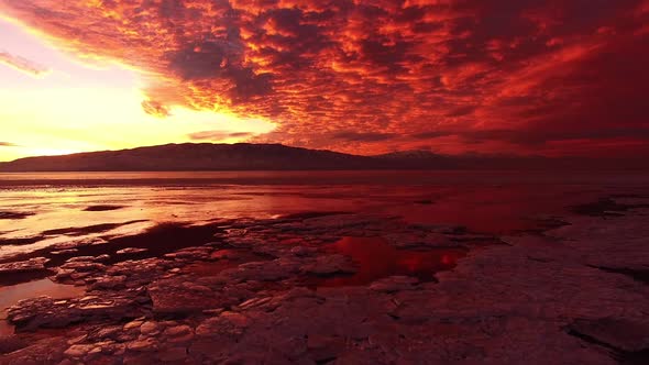 Rising view from ground of colorful sunset over icy lake