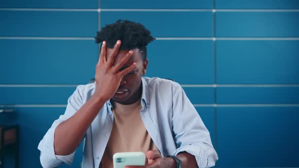 Young Annoyed African American Man Get Angry After Seeing Message on Phone