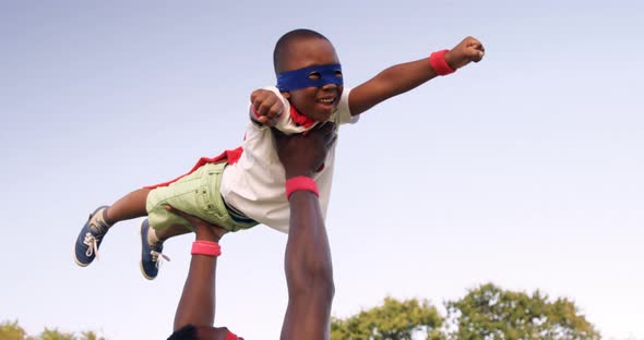 Man Carrying his Son in Costume of Superheroes alt