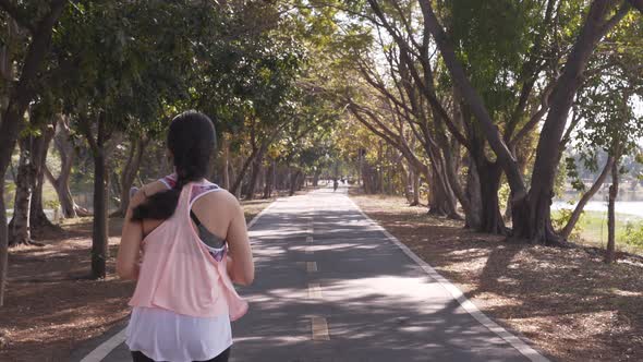 Asian woman running at park