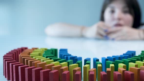 Line up of Dominoes in Rainbow Falling Colors with LGBT Colors of a Hand