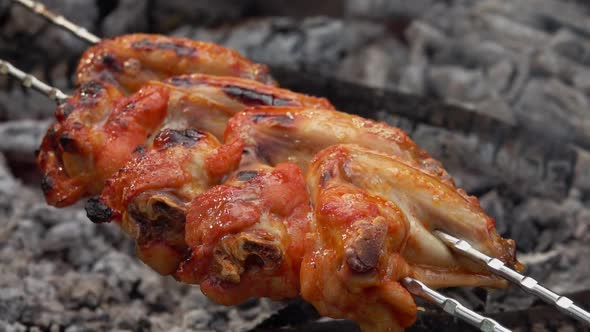 Close-up of the Mouthwatering Chicken Wings Are Flipped Above the Open Fire