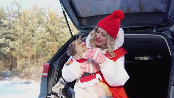 Woman and Cute Dog Enjoying Outdoors at the Mountain Into the Car