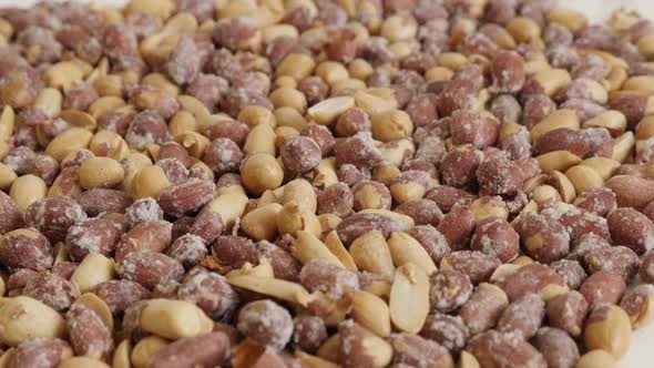 Shallow DOF roasted peanuts on white background 4K 2160p 30fps UltraHD tilting footage - Arachis hyp