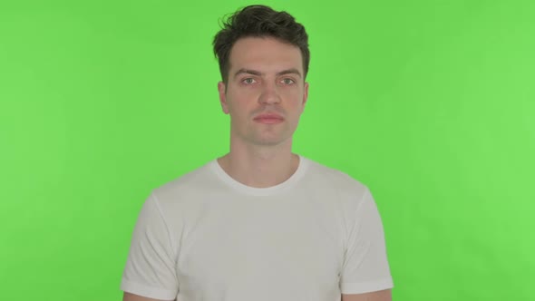 Serious Young Man on Green Background