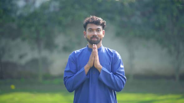 Indian man doing Namaste Pose or Namaskarasana in an Indian traditional outfit Kurta Pajama