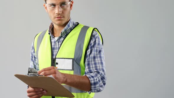 Male architect writing on clipboard