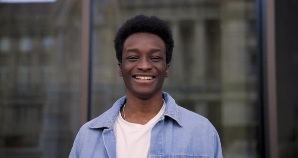 Young happy black man slow motion portrait laughing and looking at camera