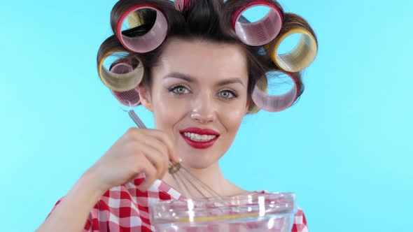 Woman in Hair Rollers Cooking and Smiling