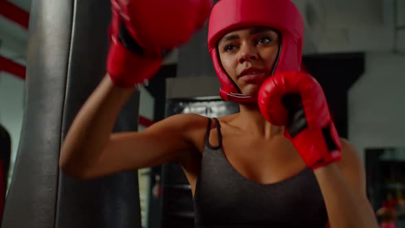 Active Fit African Woman Fighter in Headgear and Gloves Practicing Shadow Boxing