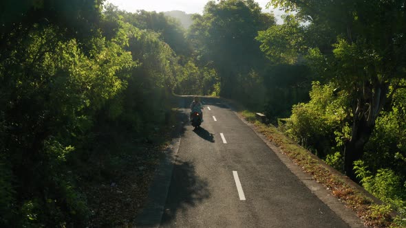 Aerial footage of people is driving the motorbike in Nusa Penida Island.