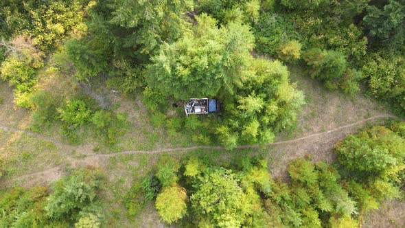 Blue, abandoned pick up truck filled with garbage in the woods of British Columbia at sunset. High a