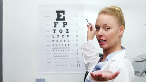 Female optometrist pointing at eye chart