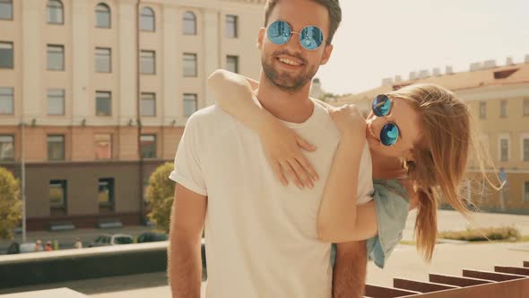 Portrait of smiling beautiful female and her handsome boyfriend posing outdoors