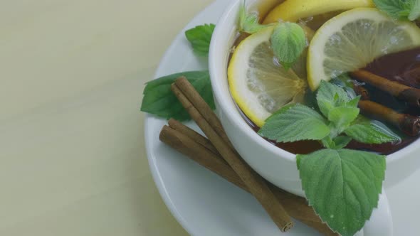 Black and Green Tea with Lemon Cinnamon Sticks and Mint Leaves Rotating