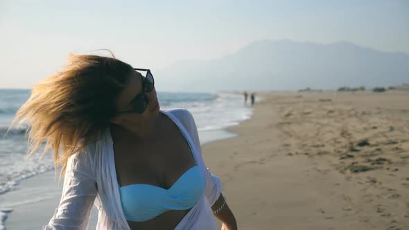 Close Up of Young Girl with Blonde Hair Spinning on Coast on a Sunny Day