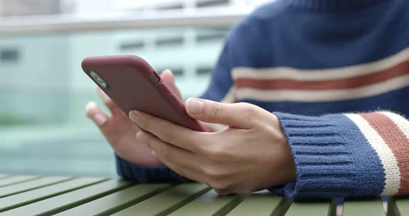 Woman play game on mobile phone at outdoor cafe