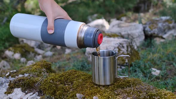 Warm Tea Poring Out From a Thermos in Cup
