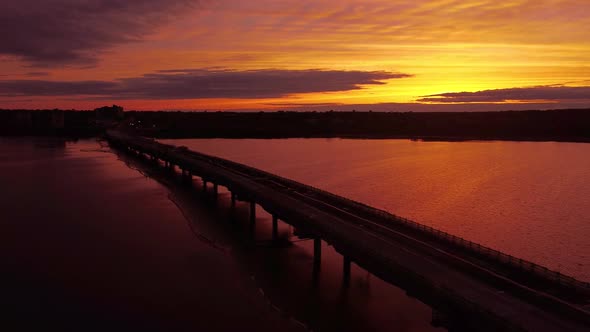 Aerial sunset over bridge under construction side dolly shot