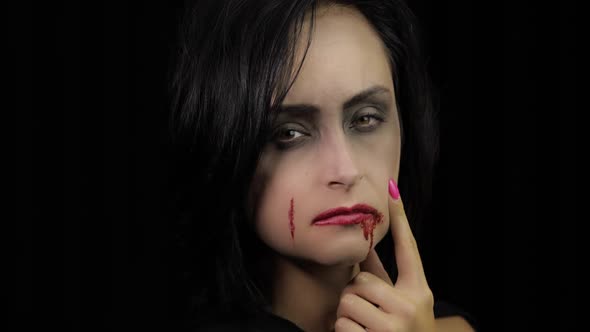 Vampire Halloween Makeup. Woman Portrait with Blood on Her Face.