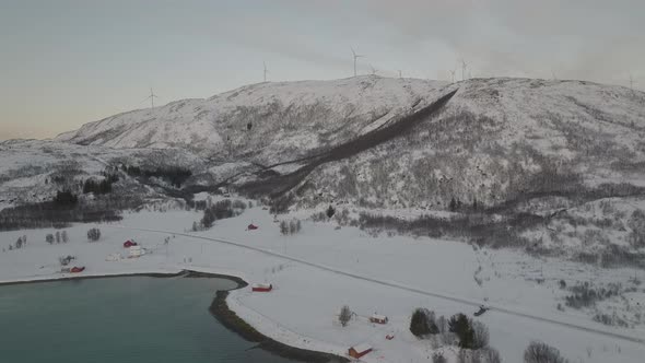 Wind Turbine Field At Top Of Snowy Norwegian Hills Landscape, Aerial
