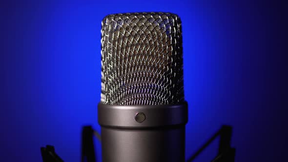 Studio Condenser Microphone Rotates on Blue Background
