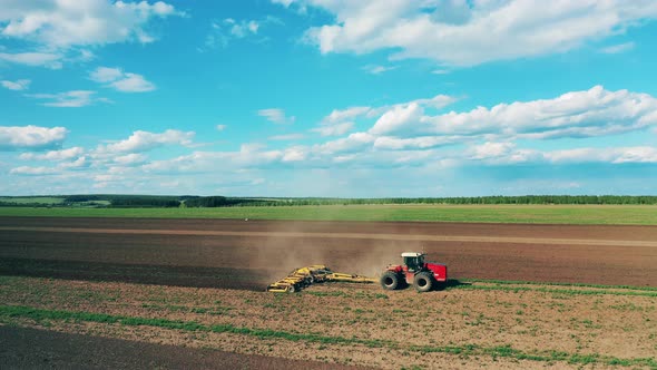 Modern Tractor Works on a Land, Sowing.