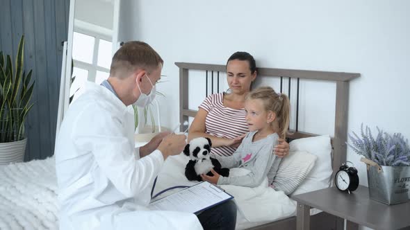 Doctor Examining Toy of Child During Home Visit