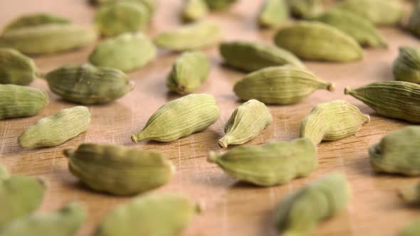 Dried cardamon seeds on a cutting wooden board