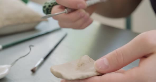 Woman Making Doll Ceramic Part Close Up. Female Sitting and Creating Ear for Doll at Home at Table