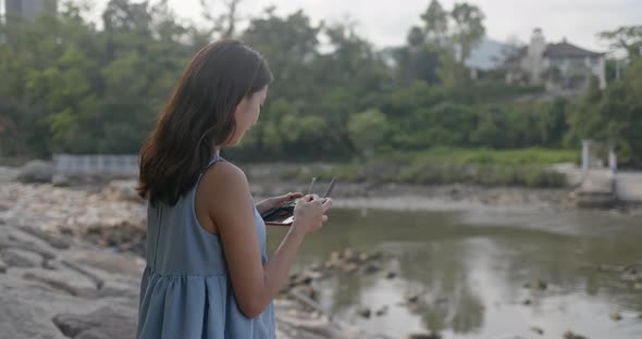 Woman Fly Drone and Stand at The Seaside