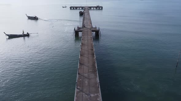 Aerial view from a drone of a pier in a tropical sea. A lot of Thai traditional longtail fishing boa