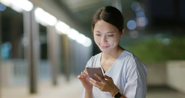 Woman use of smart phone in city at night