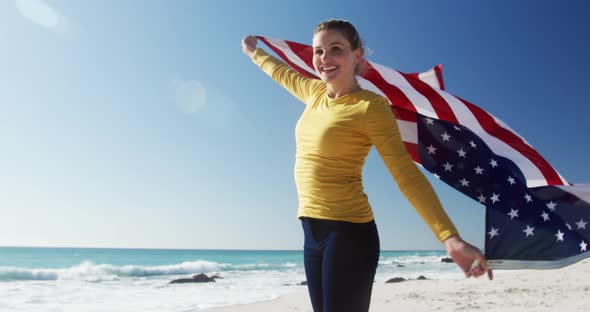 Woman holding American flag on the beach