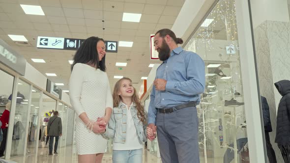 Mature Couple and Their Cute Daughter Enjoying Shopping Spree at the Mall