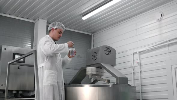 A Cheese Maker Checks a Cheese Blank for Curdling