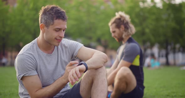 Young Caucasian Man Checking Health Data on Smartwatch After Exercise at Park