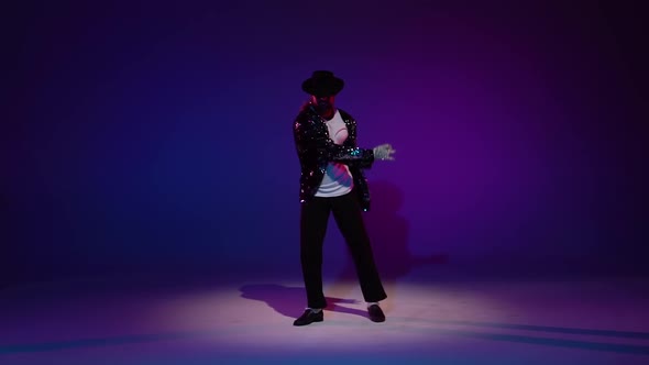 Young Stylish Man Dancing in Style Michael Jackson, Spotlight on a Blue Background. Close Up, Slow