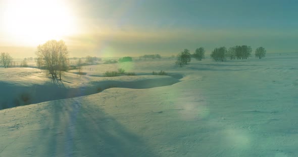 Aerial View of Cold Winter Landscape Arctic Field Trees Covered with Frost Snow Ice River and Sun